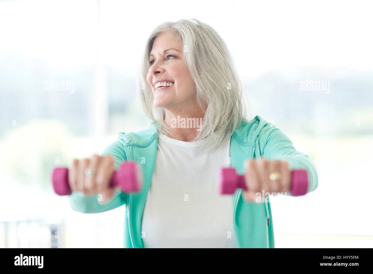Mujer de más edad con pesas de mano. Foto de stock