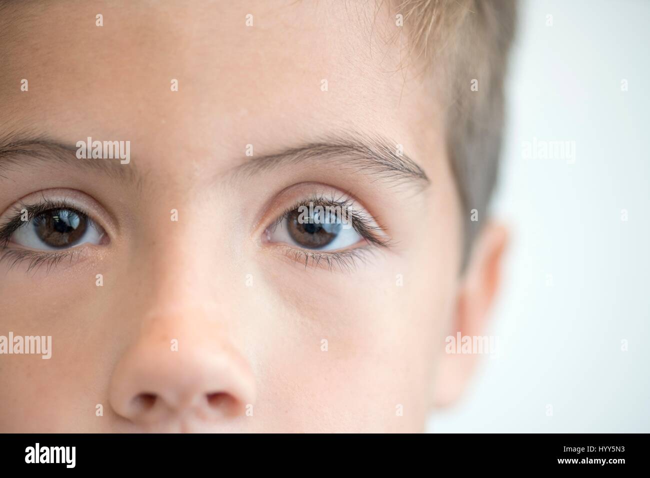 Niño con ojos marrones, cerca de retrato. Foto de stock