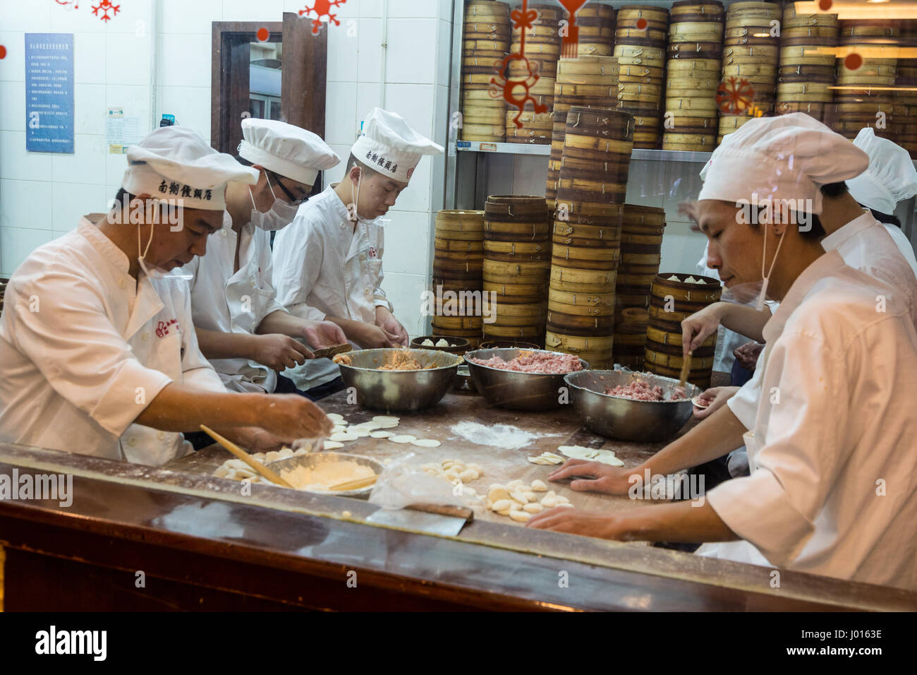 China, Shanghai. Los chefs de cocina haciendo Dumpligs en Nanxiang Dumpling Restaurante, Jardín Yuyuan. Foto de stock