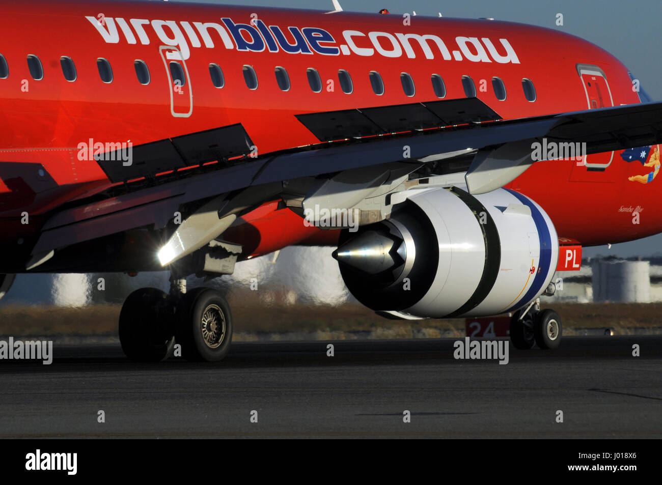 Cerca de un avión Embraer 190 Virgin Blue aterrizaje, con inversor de empuje y alerones activado. Foto de stock