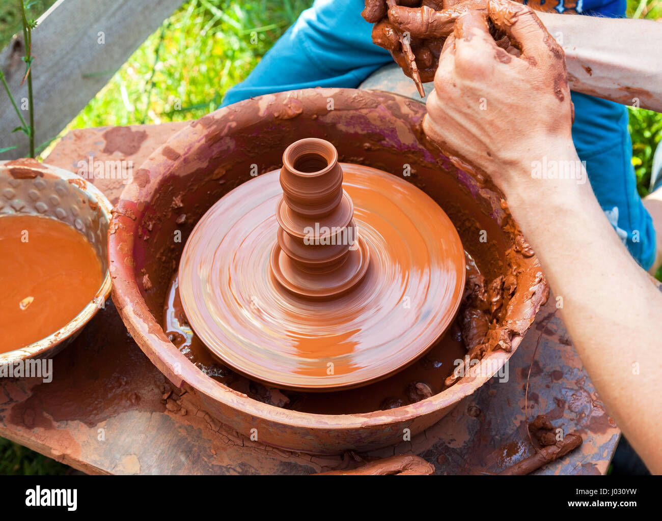 Proceso de trabajo de cerámica con torno de alfarero de arcilla en el  exterior Fotografía de stock - Alamy