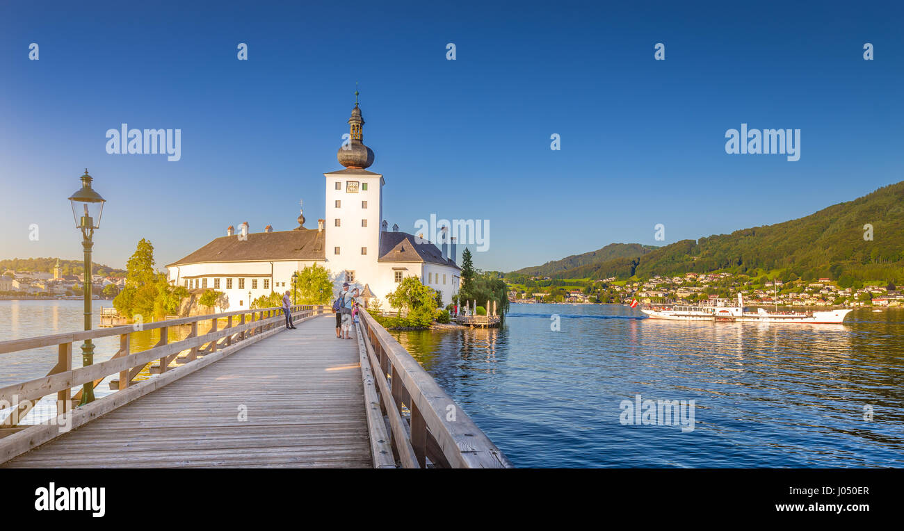 Vista panorámica del famoso Schloss Ort con el tradicional barco de vapor barco en el lago Traunsee en luz del atardecer al atardecer, Gmunden, Salzkammergut, Austria Foto de stock