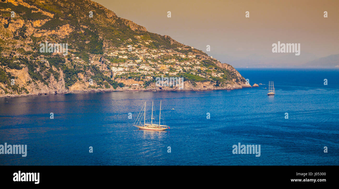 Vista panorámica de los yates de vela en el Mar Mediterráneo, en la famosa costa de Amalfi en la hermosa luz del atardecer dorado al atardecer en verano, Positano, Italia Foto de stock