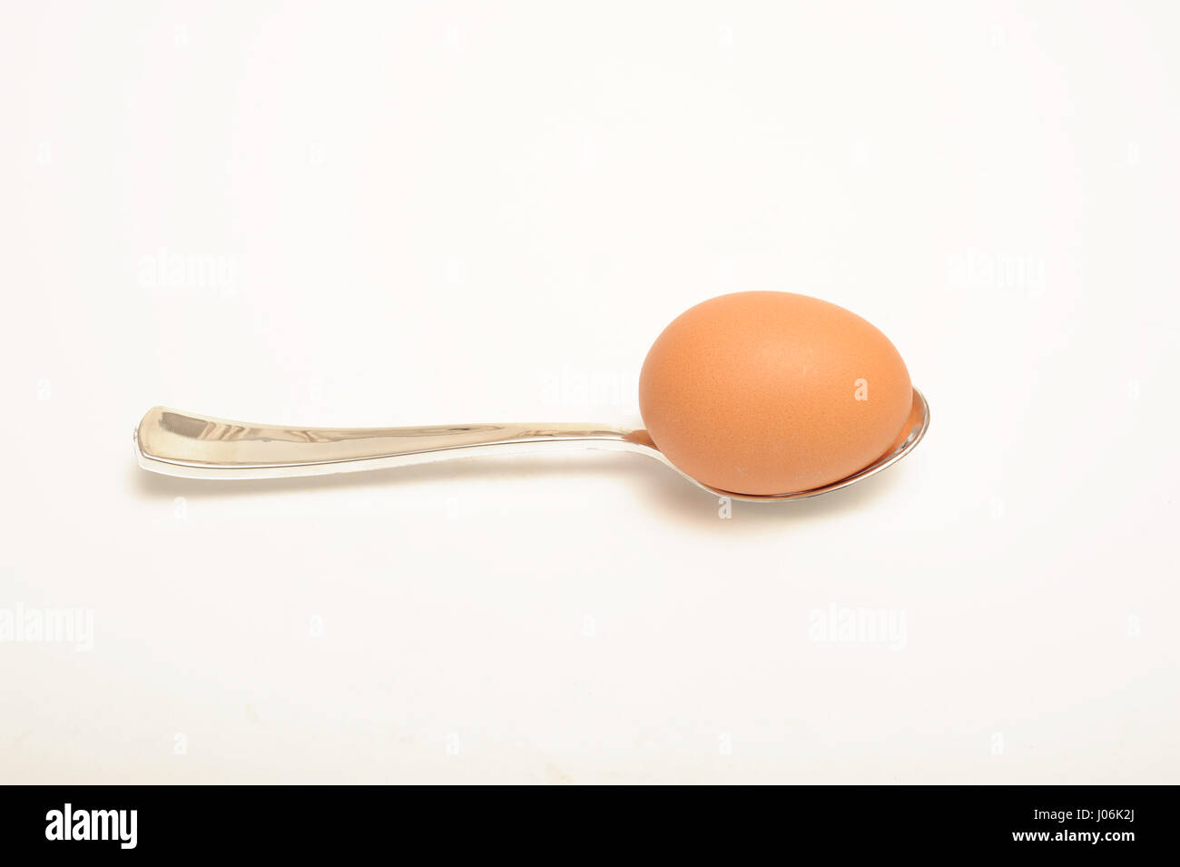 Huevo y cuchara aislado en blanco, Foto de stock