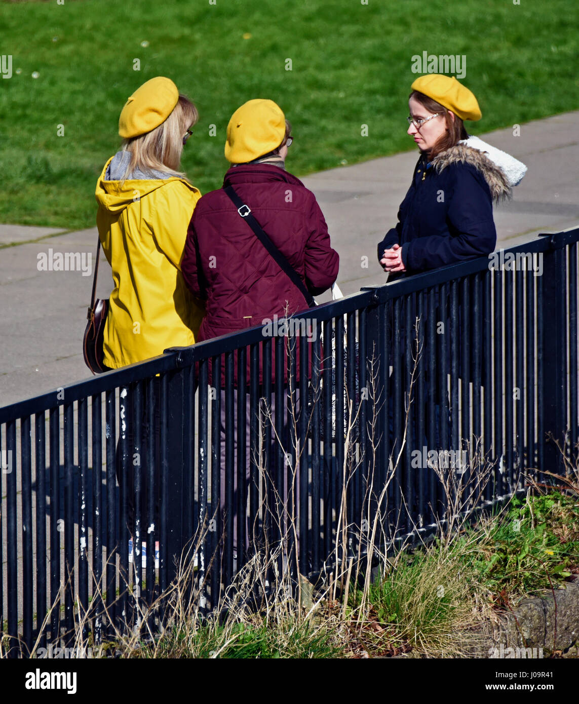 Tres mujeres vistiendo gorras amarillas. En Kendal, Cumbria, Inglaterra, Reino Unido, Europa. Foto de stock