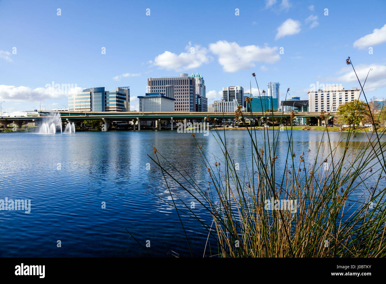 Orlando, Florida, Lago Lucerna, centro, vista, agua, reflexión, edificios de oficinas, puente de la autopista, horizonte urbano, fuente, FL170222173 Foto de stock
