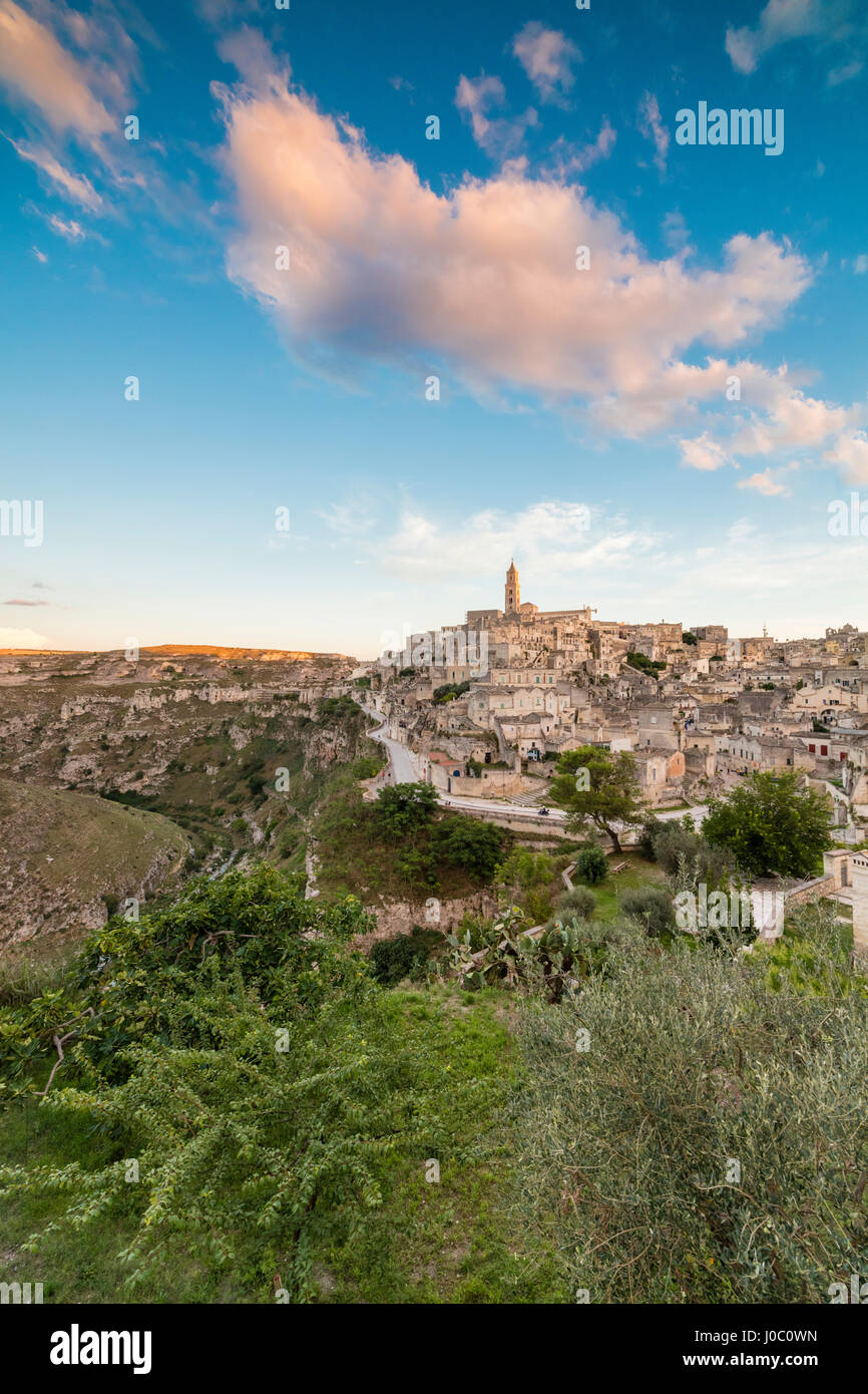 Puesta de sol sobre el casco antiguo y centro histórico llamado Sassi, encaramado en las rocas en la cima de la colina, Matera, Basilicata, Italia Foto de stock