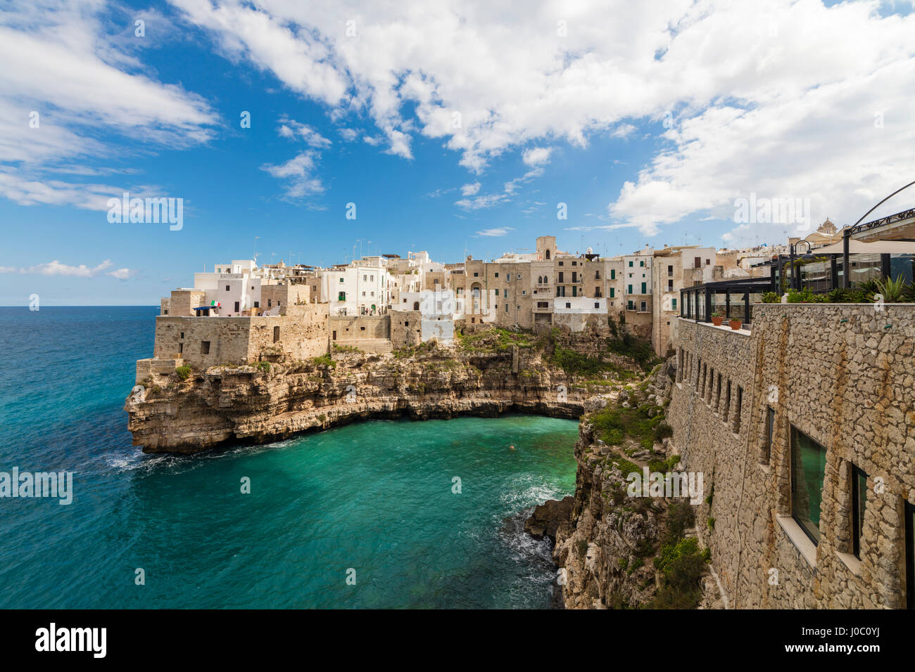 Mar turquesa enmarcado por la vieja ciudad encaramada sobre las rocas, en Polignano a Mare, Provincia de Bari, Puglia, Italia Foto de stock