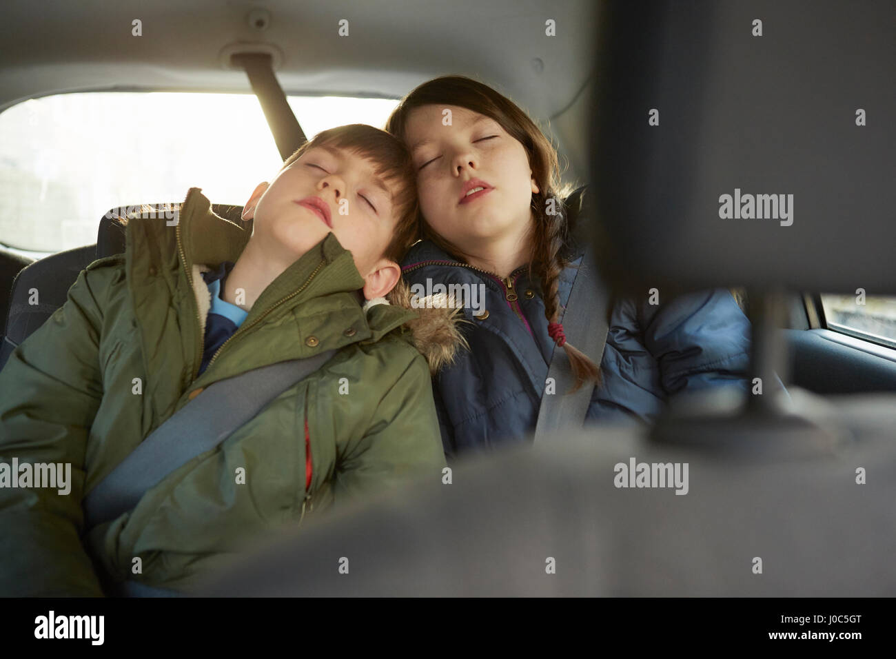 Chico y su hermana dormida en el coche backseat Foto de stock