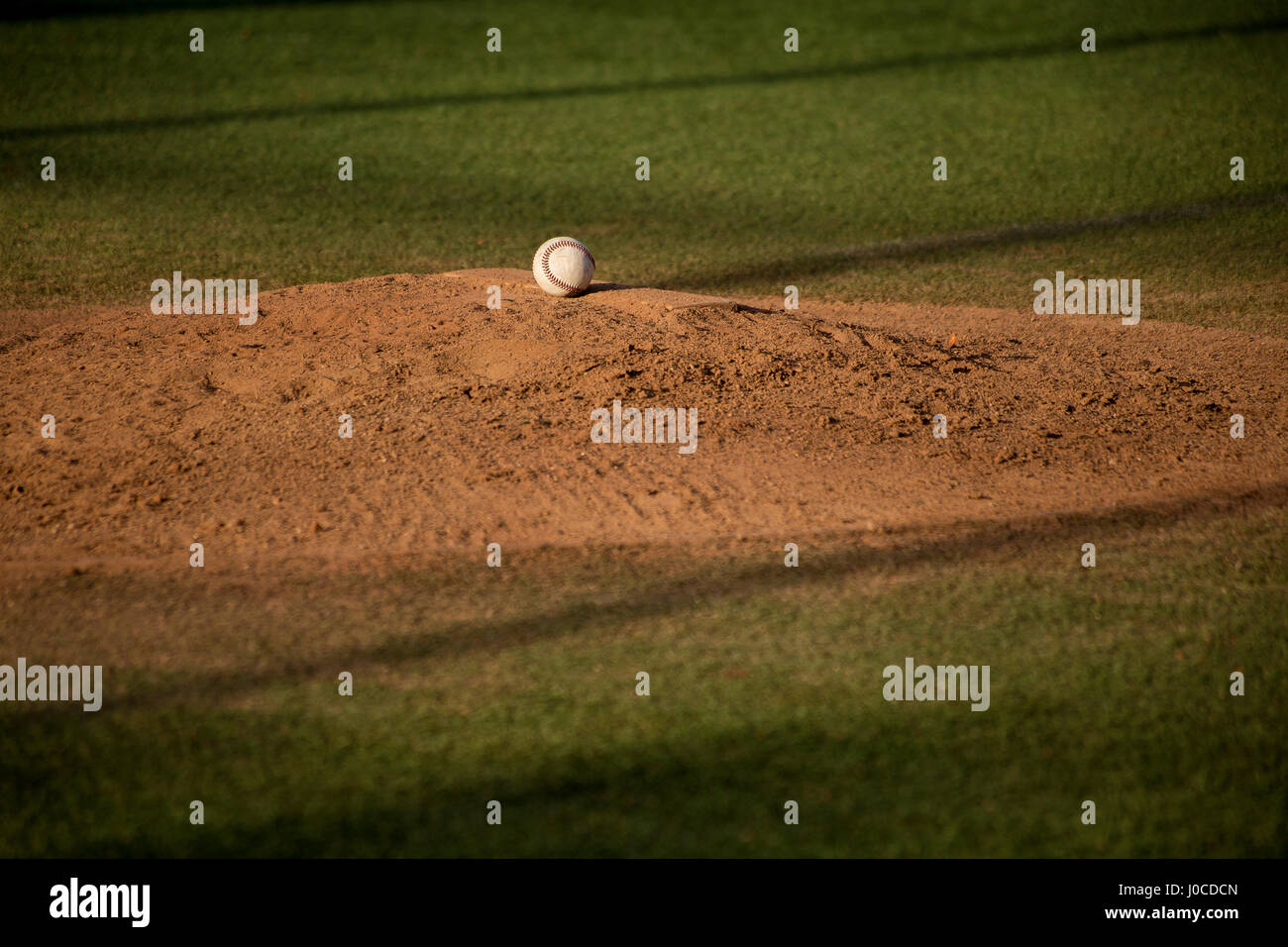 Pelota de béisbol en el montículo de arena en el campo de béisbol Foto de stock
