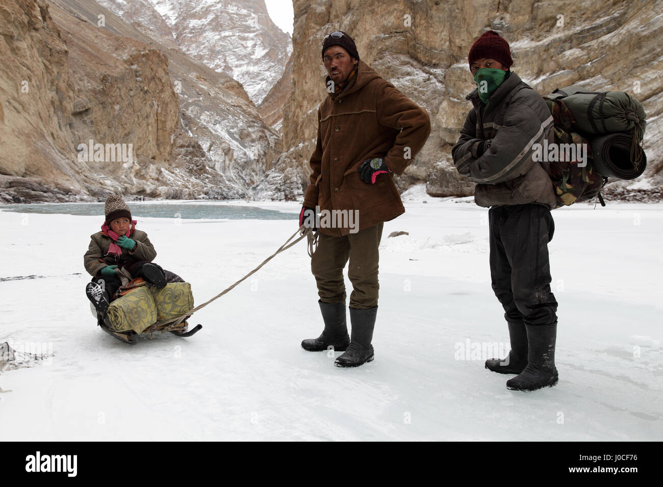 Las personas con hijos y equipaje en trineo por Frozen River, chadar trek, Ladakh, Jammu y Cachemira, la India, Asia Foto de stock