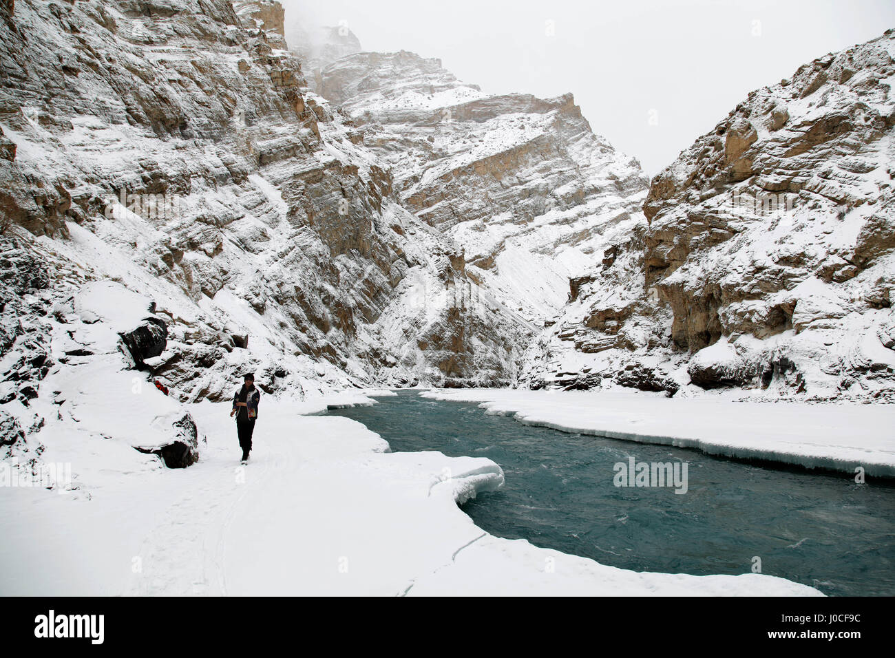 Hombre caminando por Frozen River, chadar trek, Ladakh, Jammu y Cachemira, la India, Asia Foto de stock