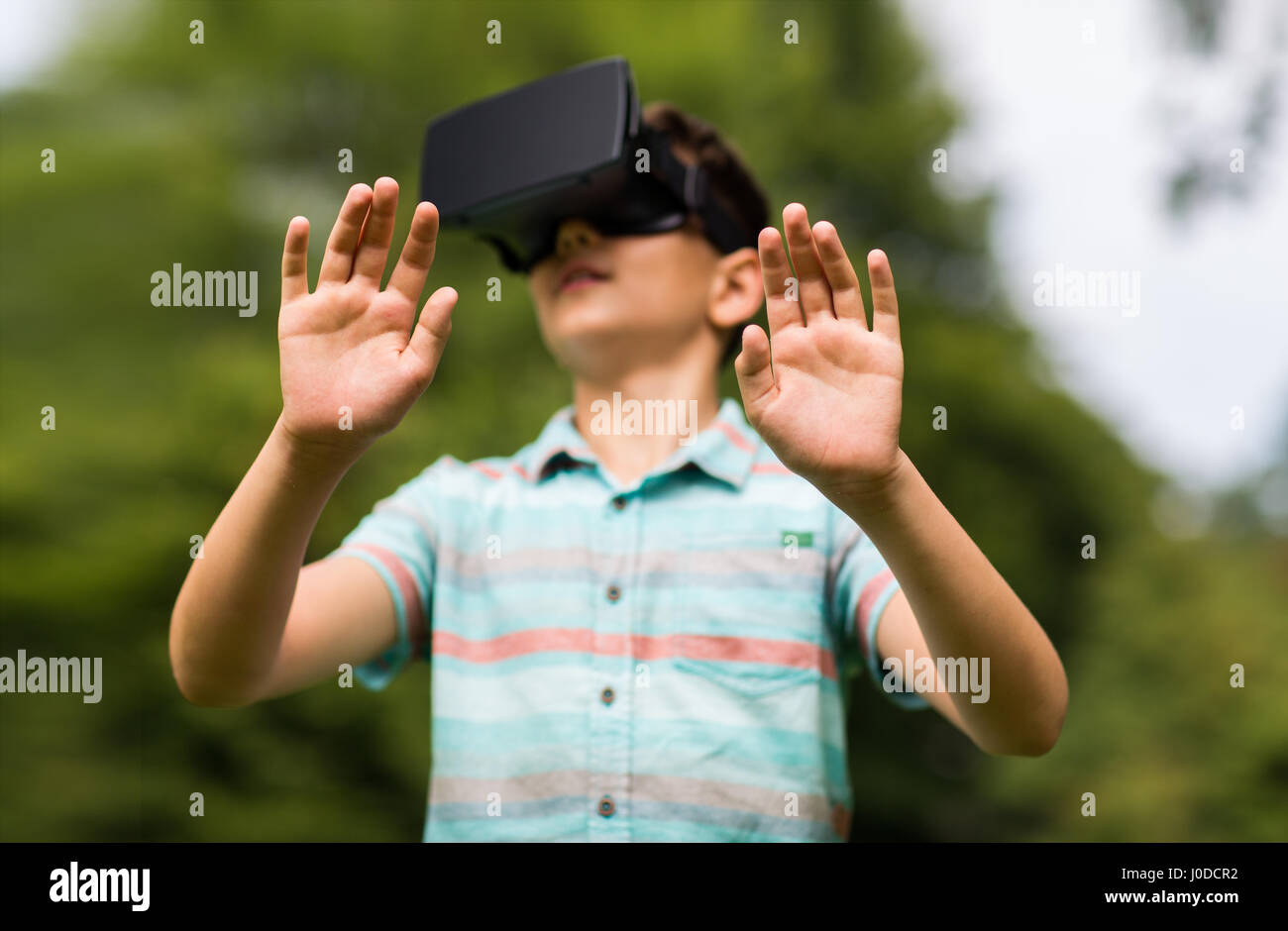 Niño con casco de realidad virtual en el exterior Foto de stock