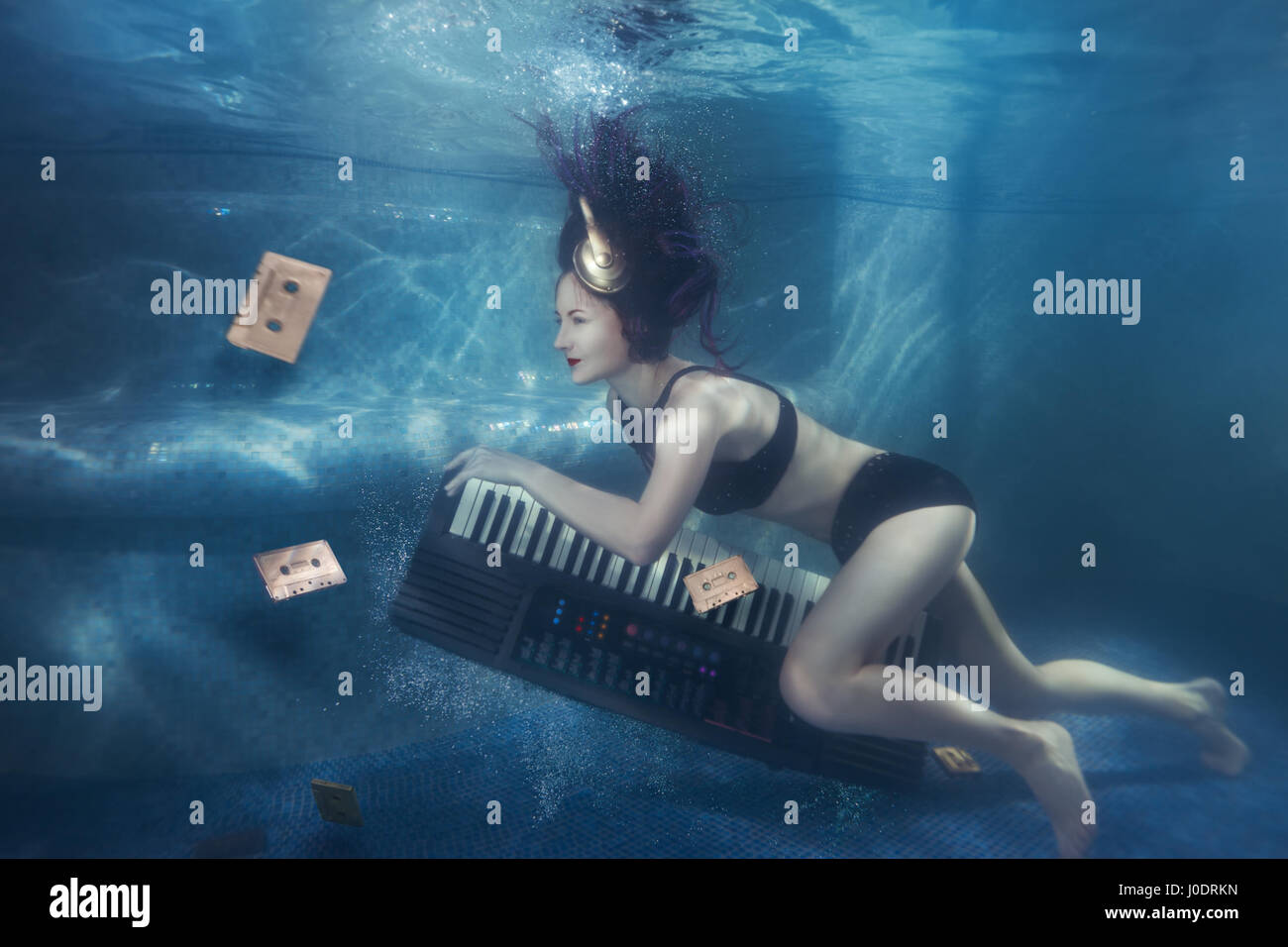 recibir beneficioso recoger Chica con piano bajo el agua sobre su cabeza para auriculares Fotografía de  stock - Alamy