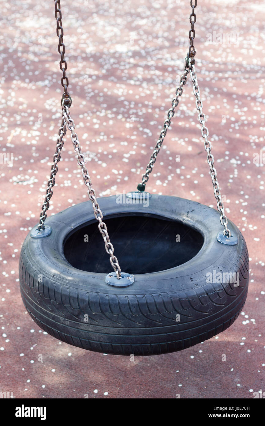 Vista superior de cerca de los niños neumático de caucho negro columpio  rueda colgando de cadenas metálicas Fotografía de stock - Alamy