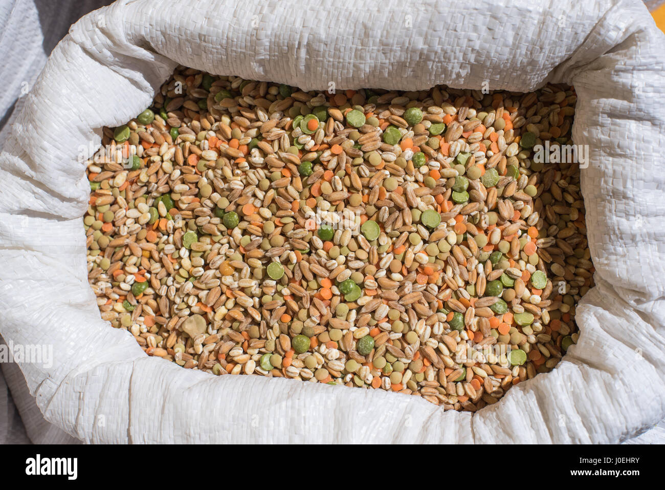 Mezcla legumbre y cereales el detalle del patrón en bolsa blanca en el estante del mercado Foto de stock