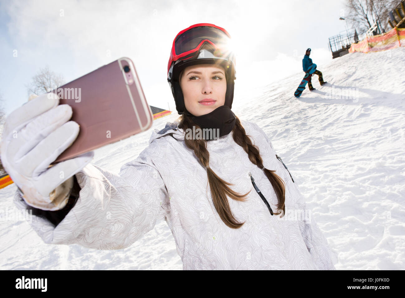 Hermosa joven snowboarder teniendo selfie con el smartphone Foto de stock