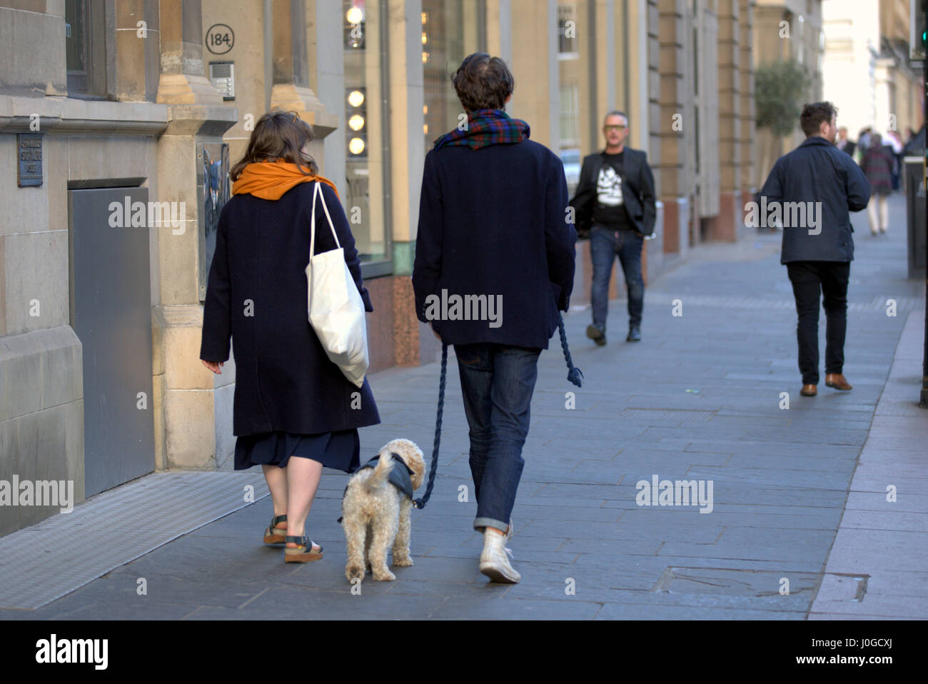 Moda joven pareja con perro a caminar en la ciudad de Glasgow Foto de stock
