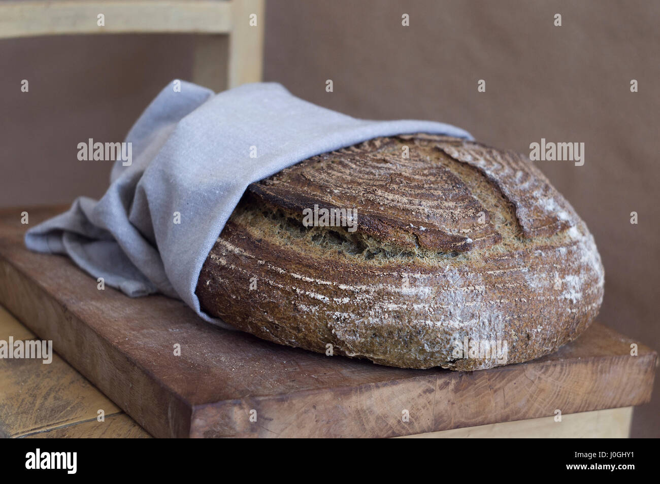 Hermoso pan artesano en una toalla sobre una tabla de madera Foto de stock