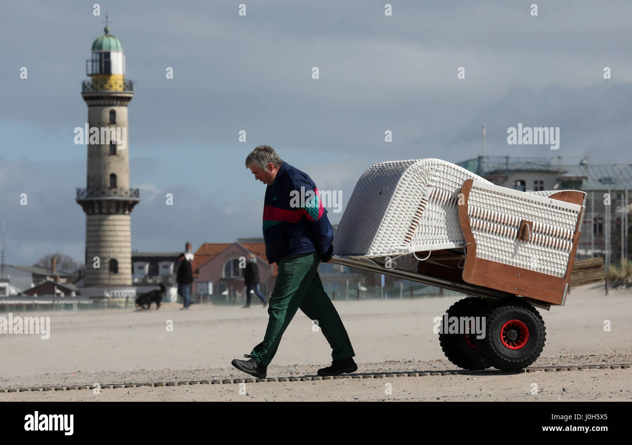 Warnemuende (Alemania). 13 Apr, 2017. dpatop - un hombre pone alquilables pueden alquilar sillas de playa para el fin de semana de Semana Santa en la ciudad de Mar Báltico Warnemuende (Alemania), 13 de abril de 2017. Según el Servicio Meteorológico Alemán (DWD), el clima seguirá siendo caprichoso y frío en este año de la Semana Santa. Foto: Bernd Wüstneck/dpa-Zentralbild/dpa/Alamy Live News Foto de stock