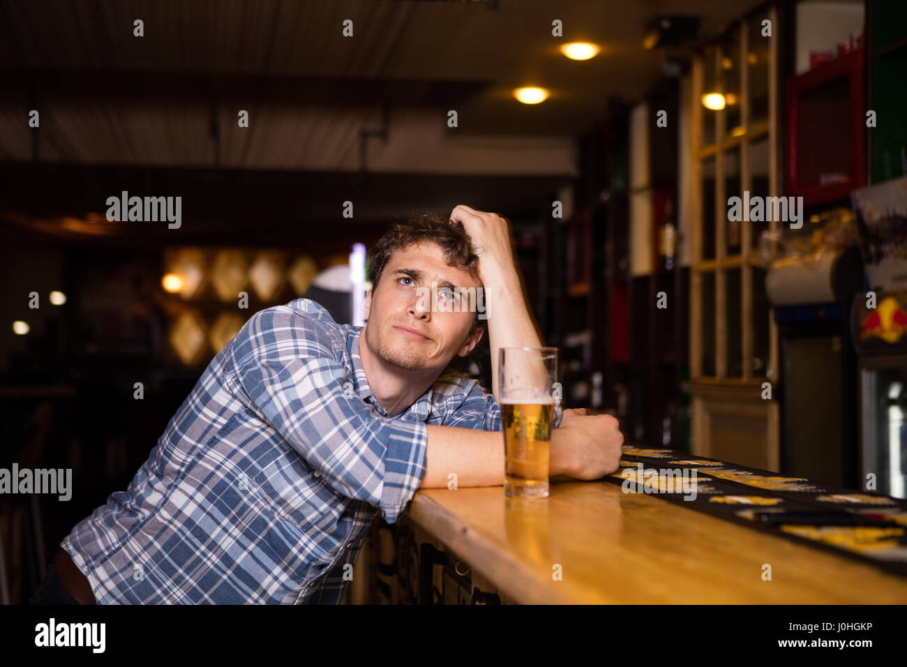 Triste solo Hombre bebiendo cerveza en el bar o pub, observando el juego  Fotografía de stock - Alamy