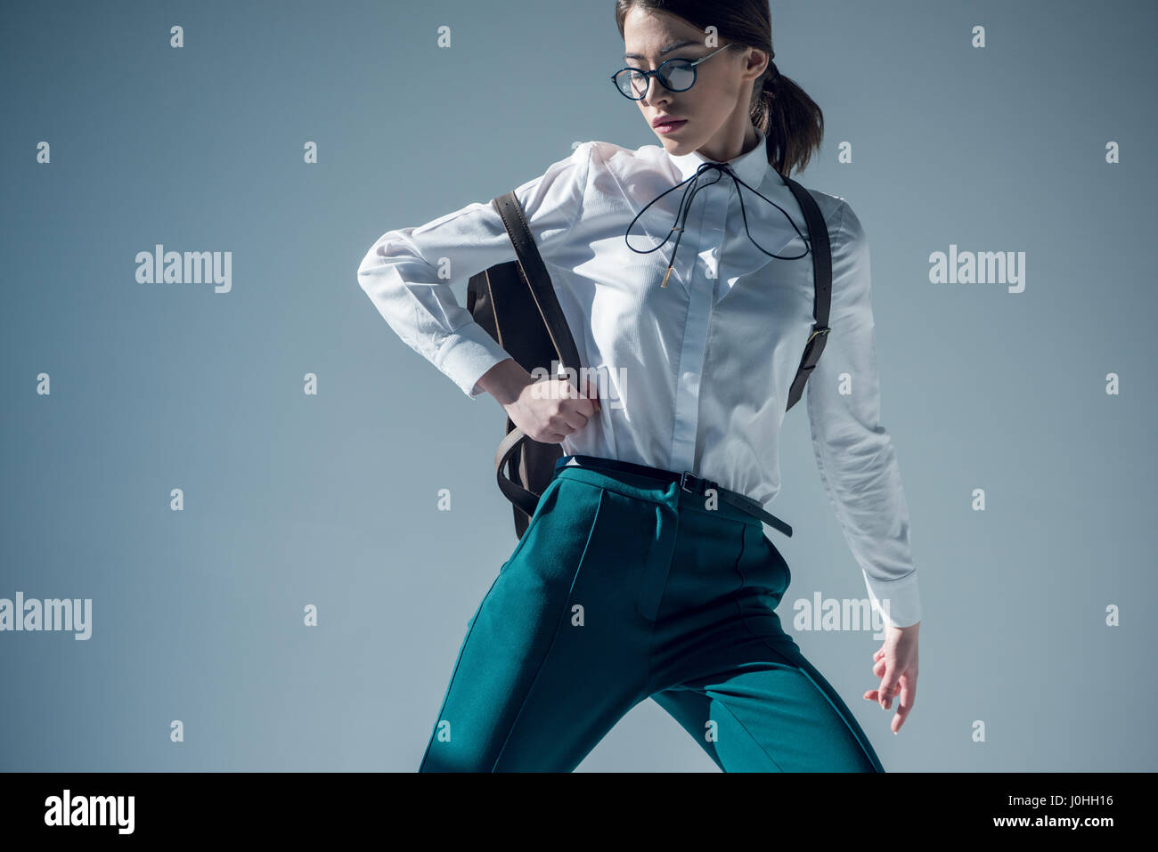 mujer en camisa blanca, pantalón verde y gafas con mochila de stock - Alamy