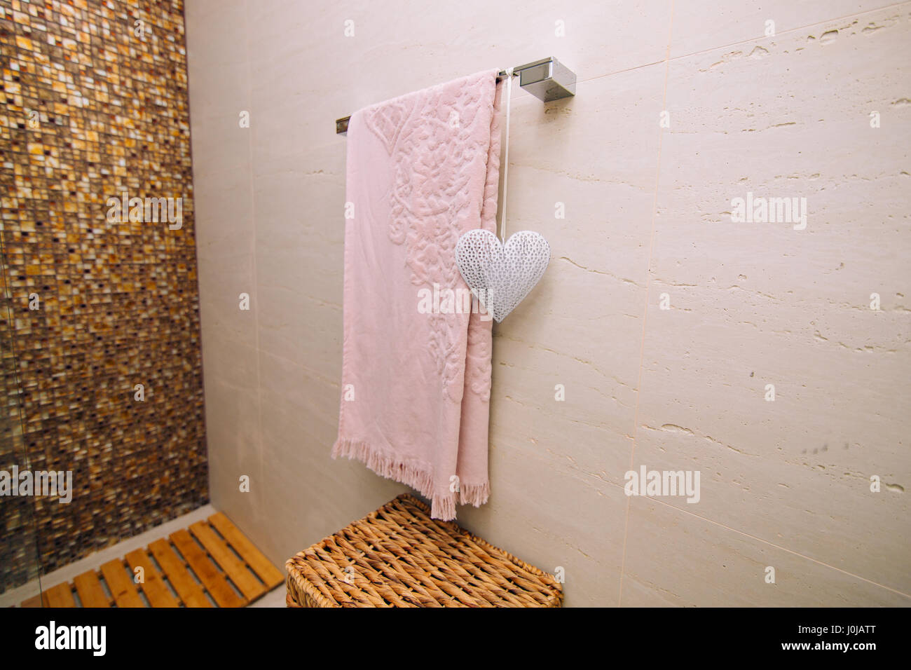 Una rosa es una toalla seca en el baño el toallero caliente. Corazón  blanco, un elemento de decoración. Cesta de mimbre para la ropa Fotografía  de stock - Alamy