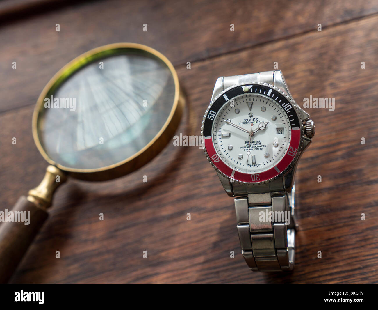 lector director Varios FAKE Rolex Watch Replica falsa lupa y falsos relojes Rolex del hombre viejo  escritorio de madera arriba Fotografía de stock - Alamy