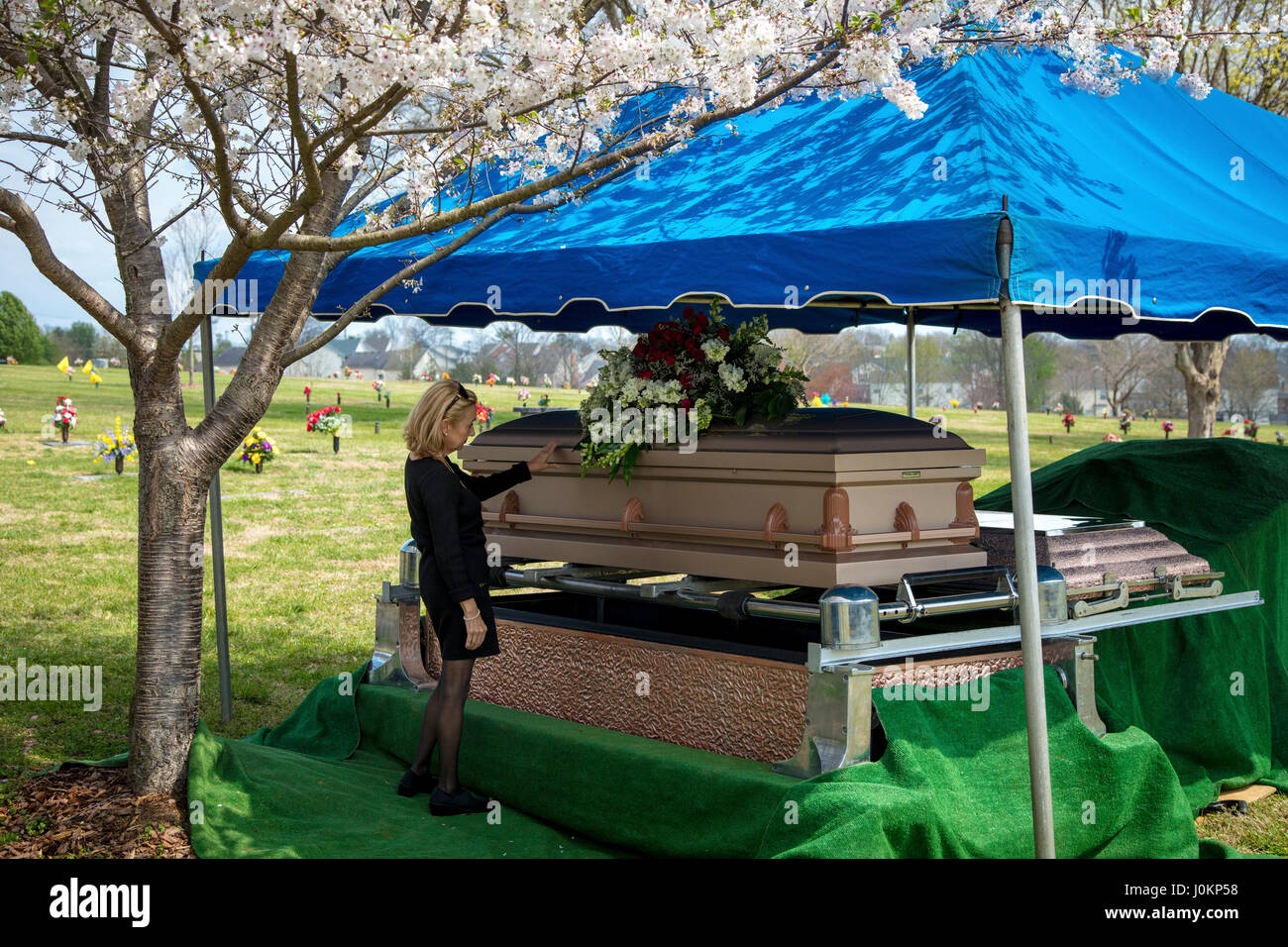 Mujer toca el ataúd del ser querido antes del entierro, Hendersonville, Tennessee, EE.UU. Foto de stock