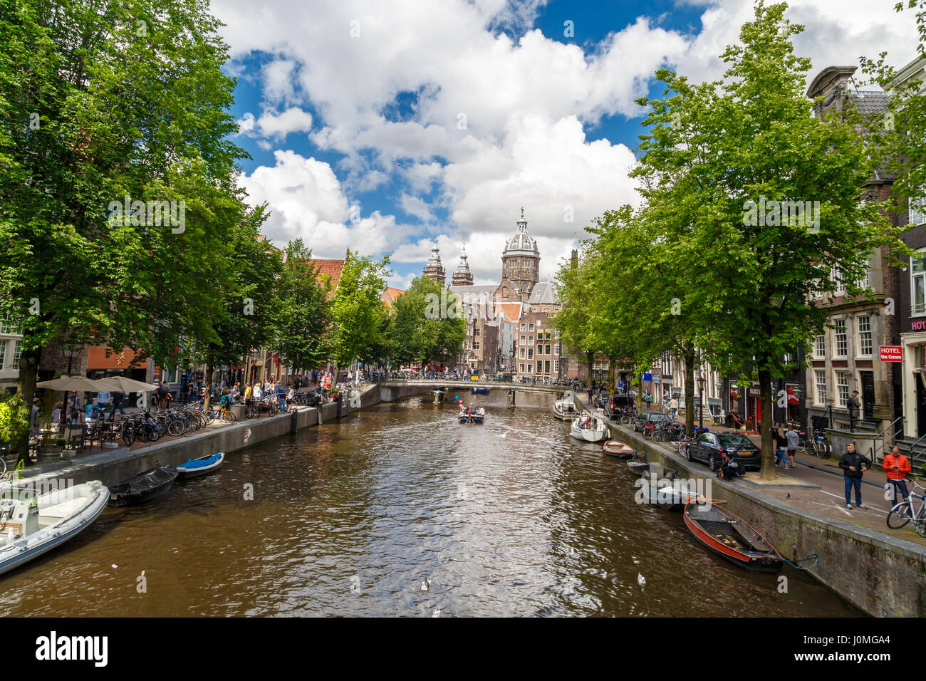 AMSTERDAM, Holanda - Julio 2, 2016 : Vista de calles con canales y típicas casas de Amsterdam sobre el cielo nublado. El Barrio Rojo es popular touristi Foto de stock