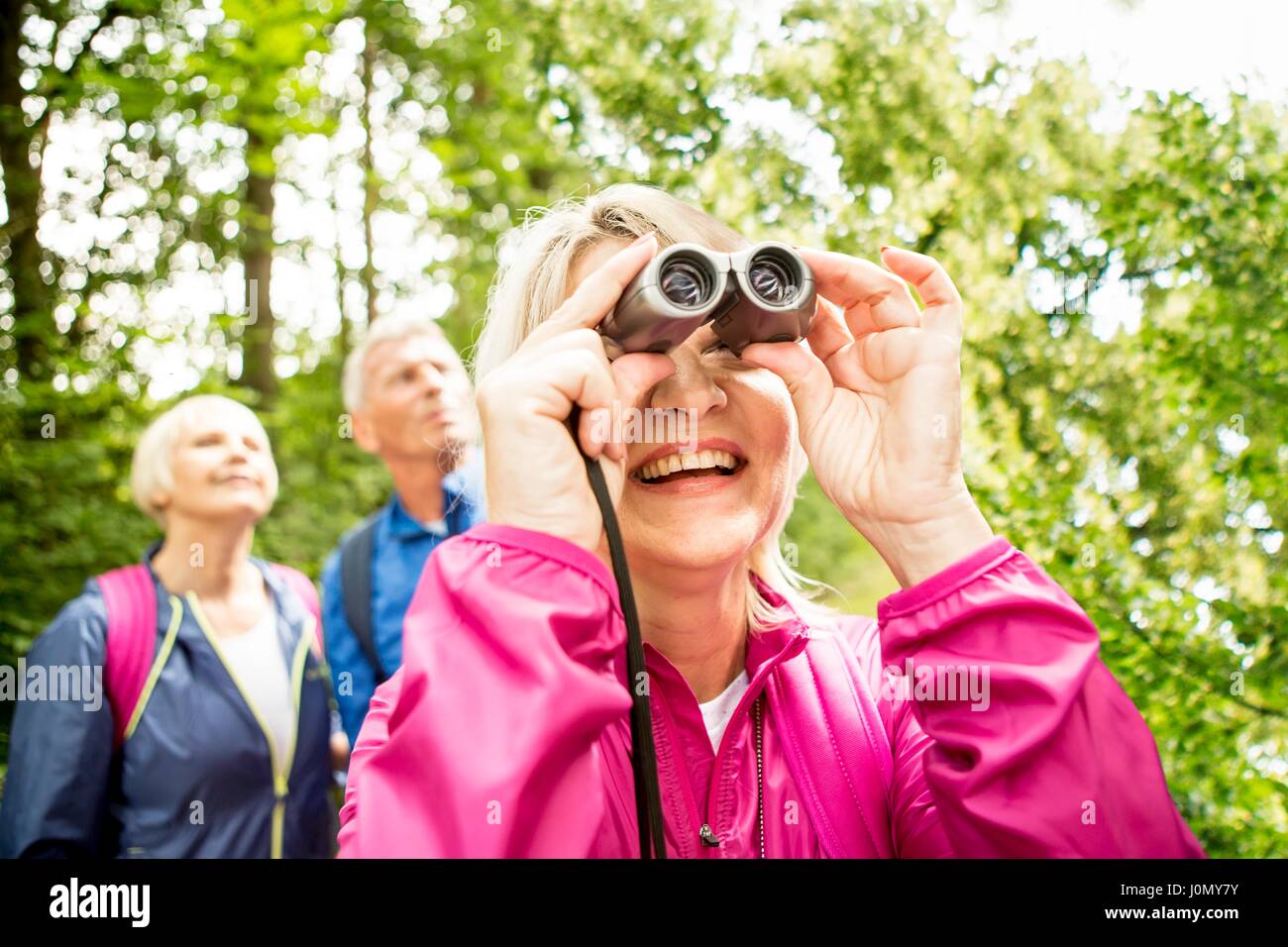 Senior mujer mirando a través de binoculares. Foto de stock