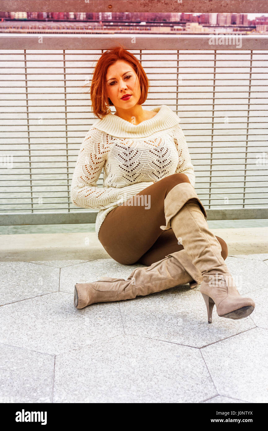 Infeliz mujer americana pensamiento fuera, vistiendo jerseys de punto  blanco, pantalones marrones, botas largas, sentado por la baranda por río  en invierno, triste, pensando Fotografía de stock - Alamy