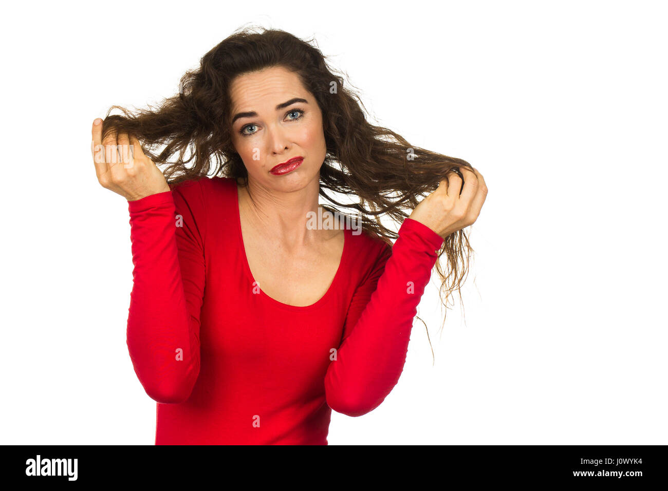 Una infeliz mujer hermosa que está teniendo un mal día de cabello aislado en blanco. Foto de stock