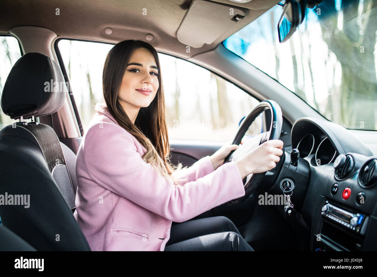 Linda morena joven chica conduciendo un coche Fotografía de stock - Alamy