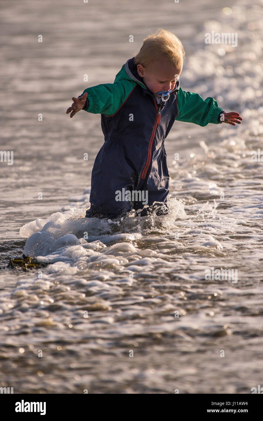 Niño Niño jugando Boy Mar Mar litoral emocionado nuevas experiencias de aprendizaje Divertirse Turismo salpicaduras disfrutando de la playa Fistral Foto de stock