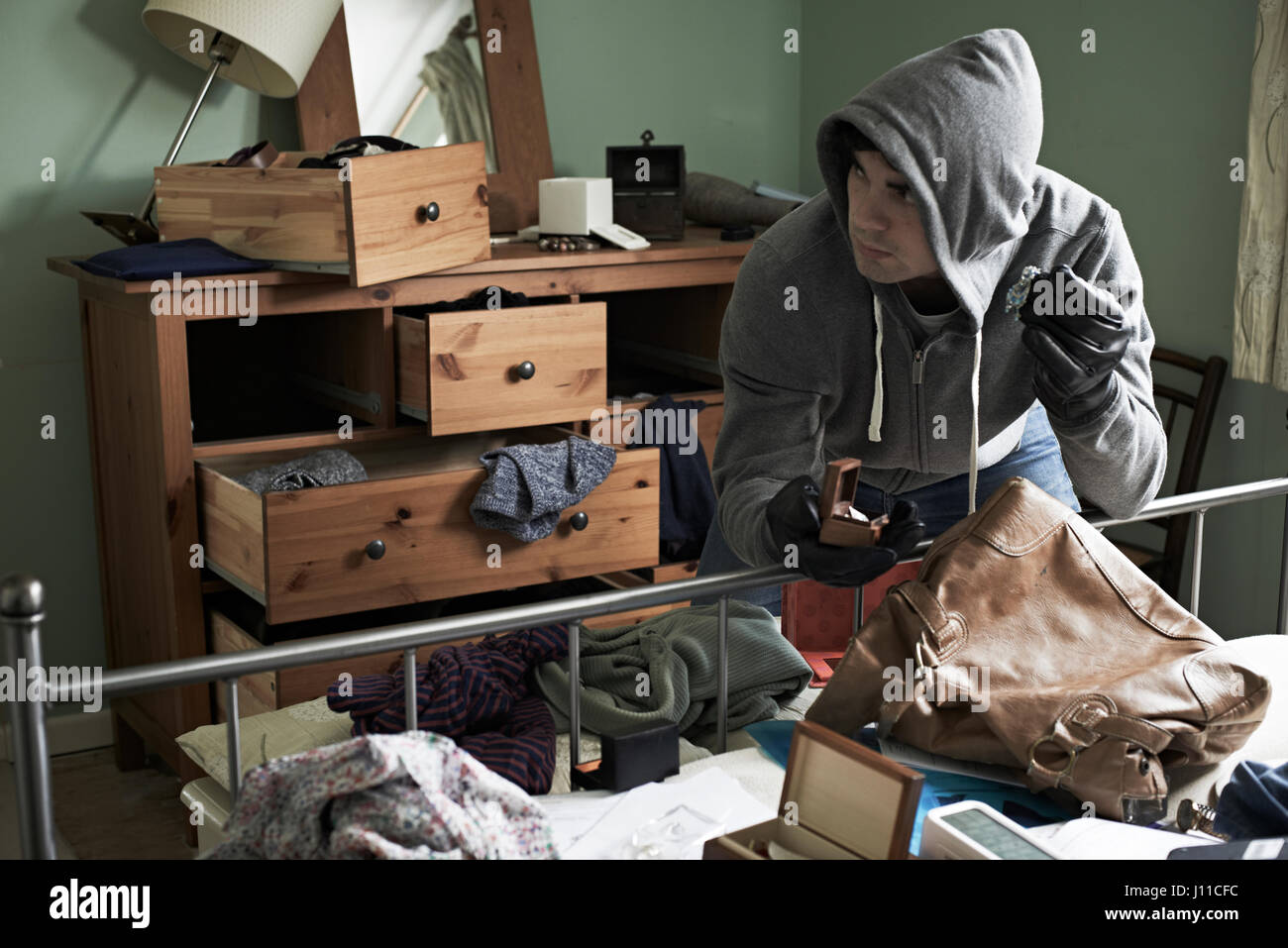 Ladrón de robar algunos objetos de la habitación durante la manguera se rompe en Foto de stock