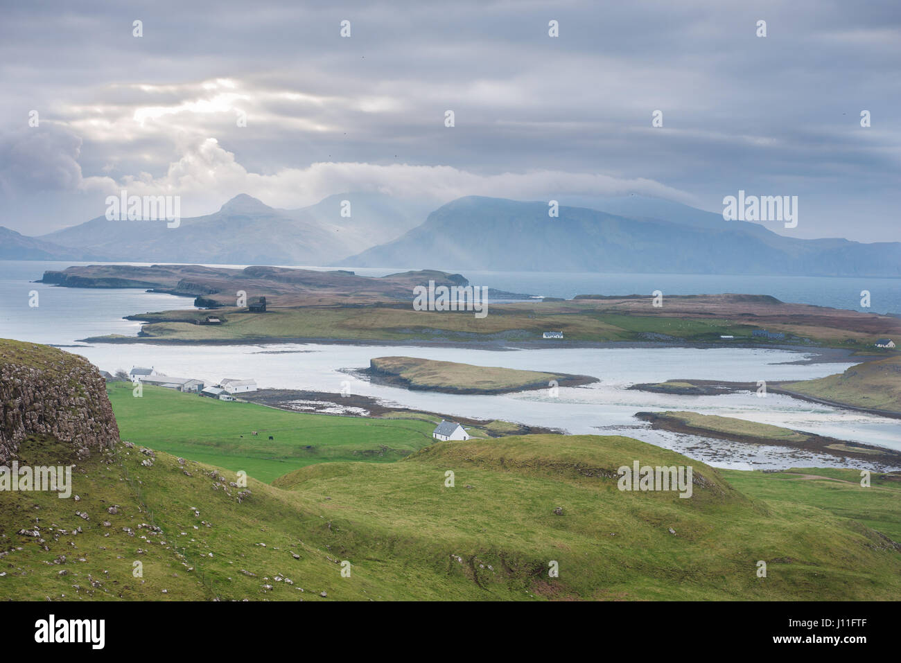 Vista desde la isla de Canna de viviendas aisladas y la isla de Scalpay. Inner Hebrides, Escocia Foto de stock