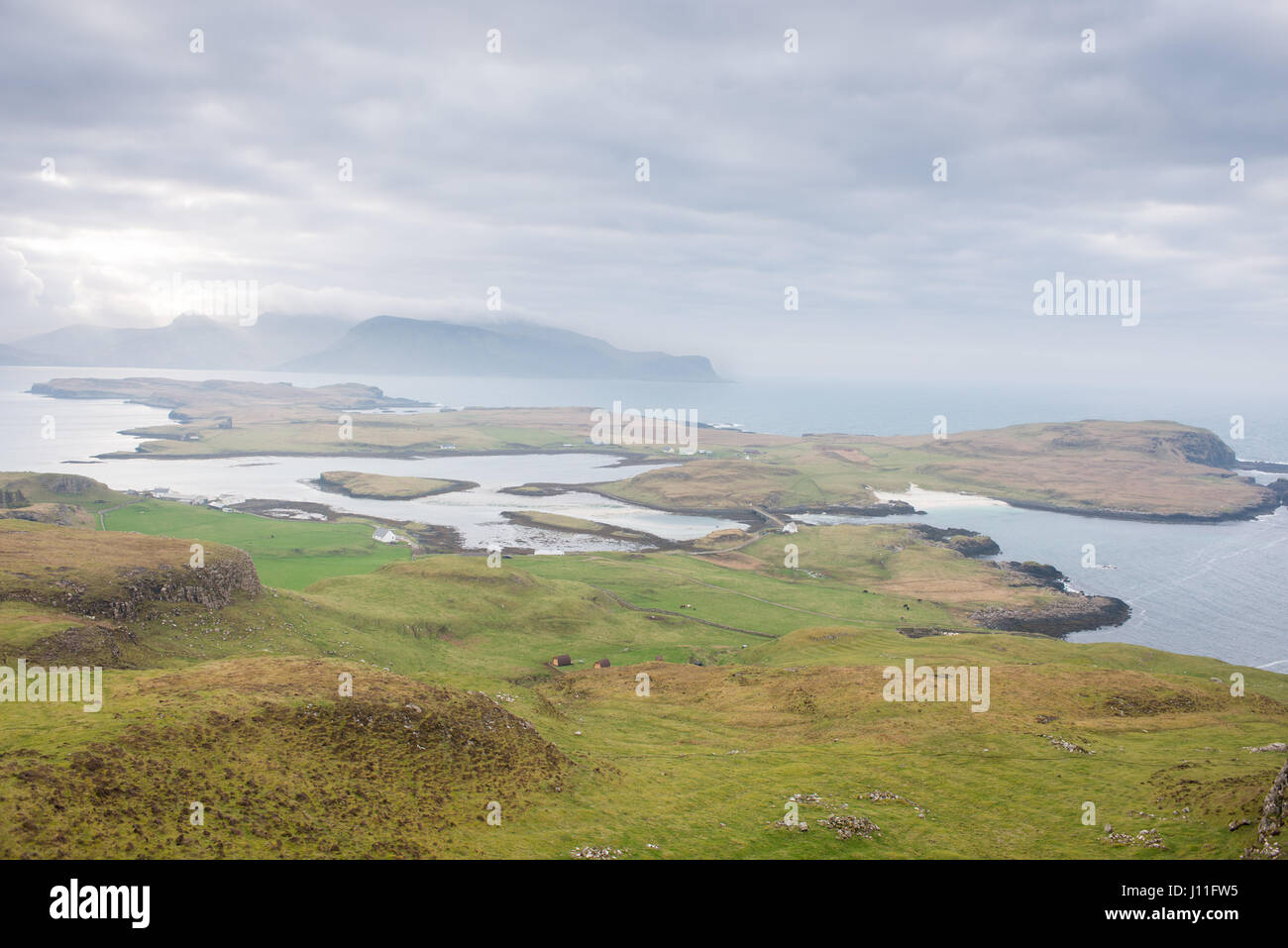 Vista desde la isla de Canna de viviendas aisladas y la isla de Scalpay. Inner Hebrides, Escocia Foto de stock