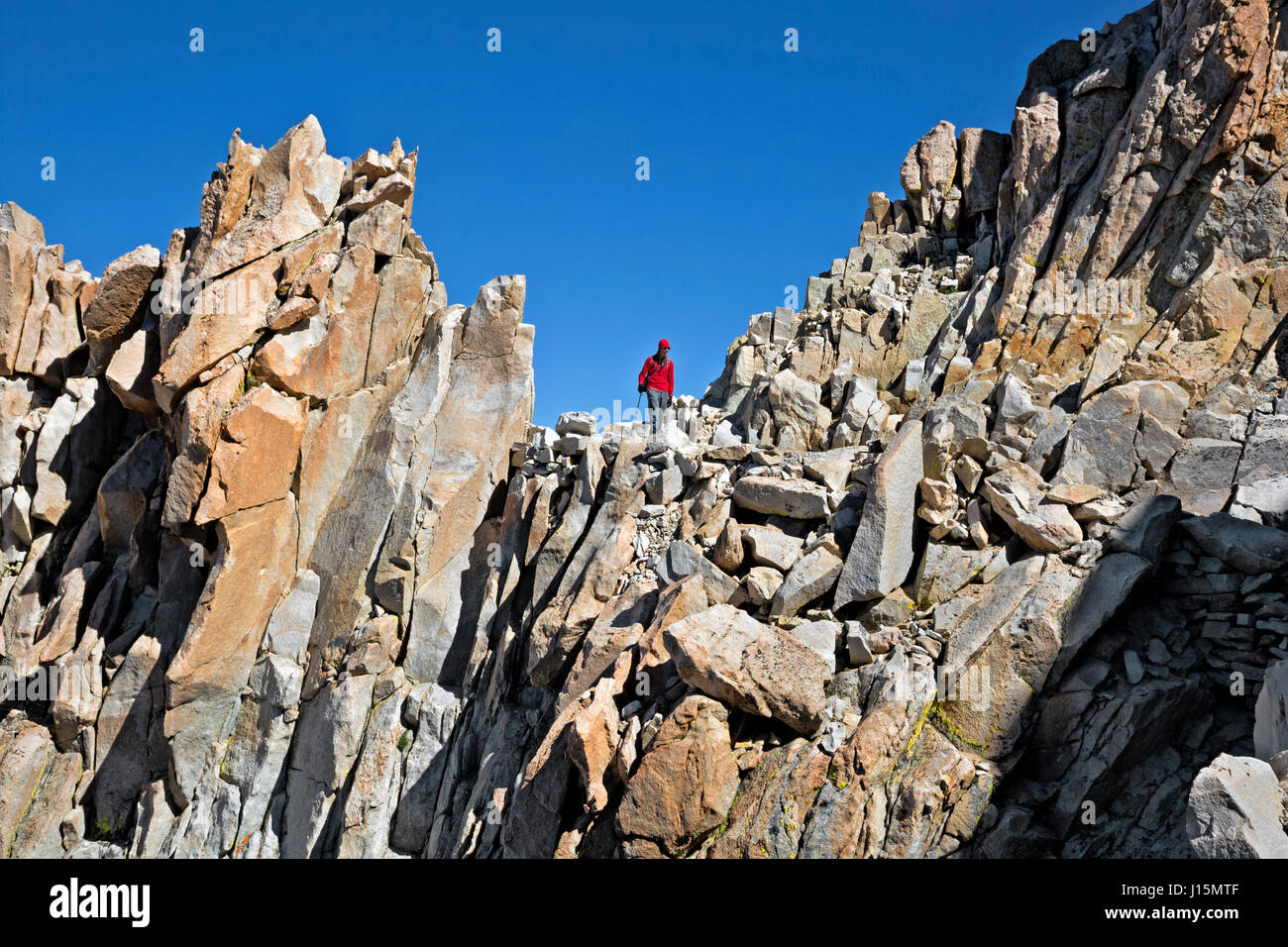 CA03239-00...CALIFORNIA - Caminante descendiendo el sendero rocoso hacia abajo desde la cima del Monte Whitney. Foto de stock