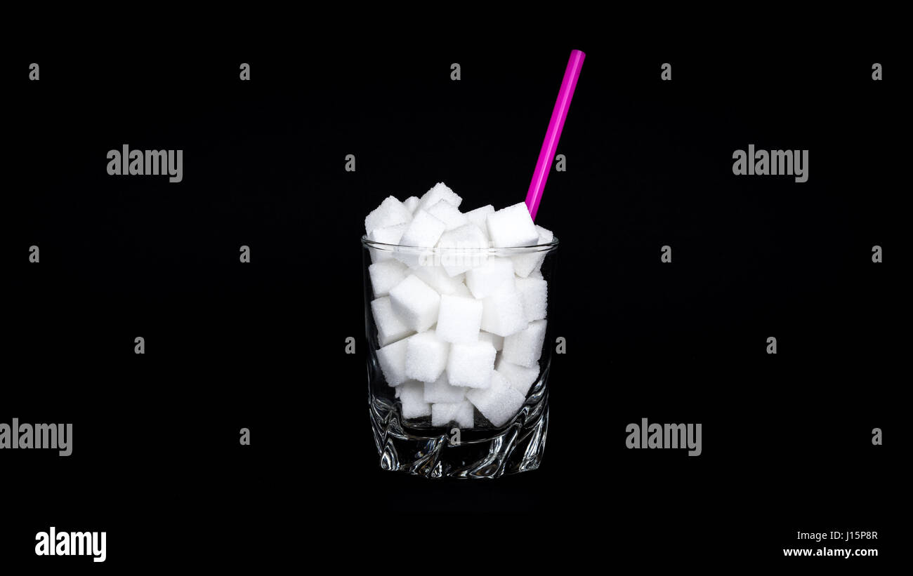 Vidrio con cubos de azúcar - Concepto de bebidas azucaradas malsana Foto de stock