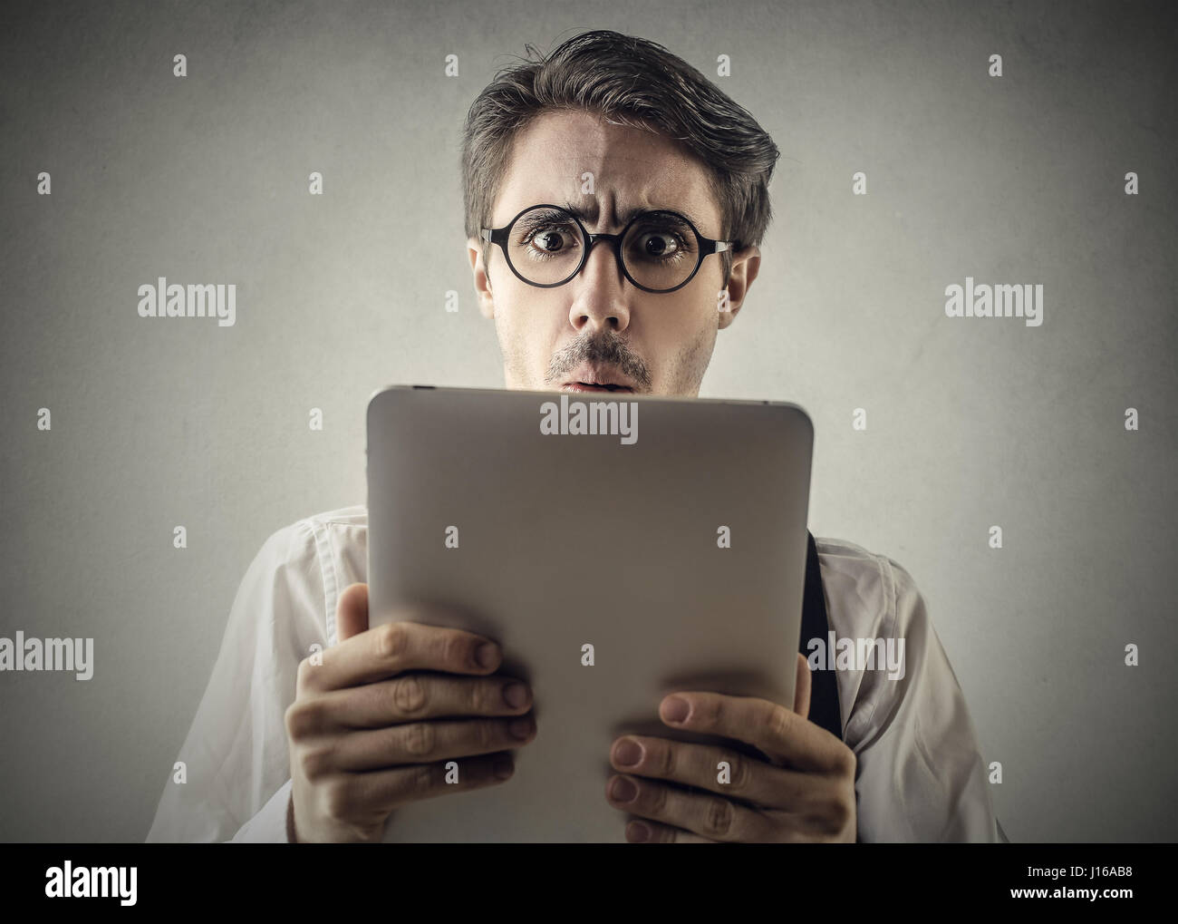 Confundido hombre mirando el tablet Foto de stock