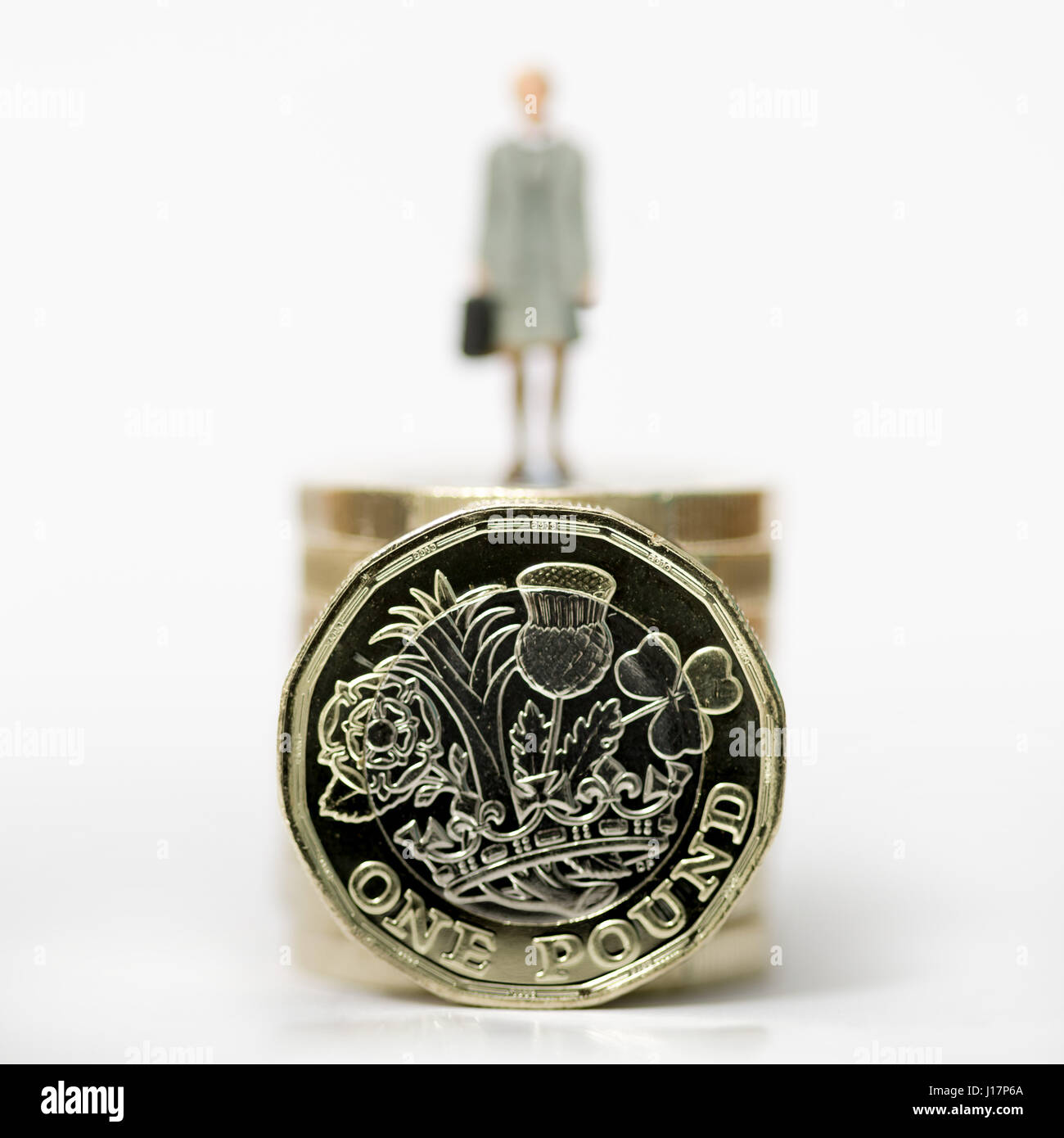 Cerrar/macro fotografía de stock modelo trabajador asalariado femenino representando en la pila de New British Pound monedas. Foto de stock