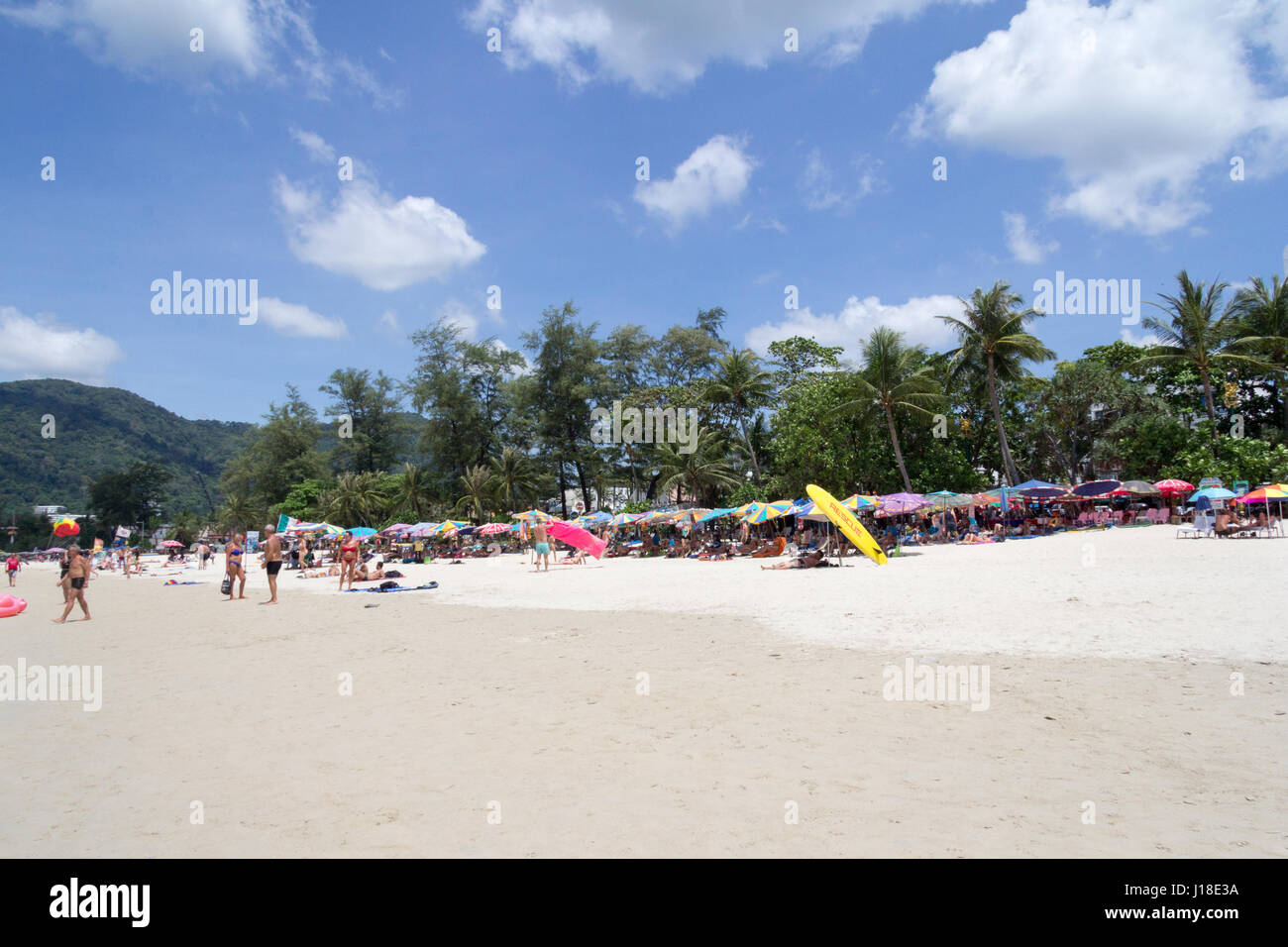 Los turistas bajo las sombrillas en la playa Patong Beach, Phuket, Thahiland Foto de stock