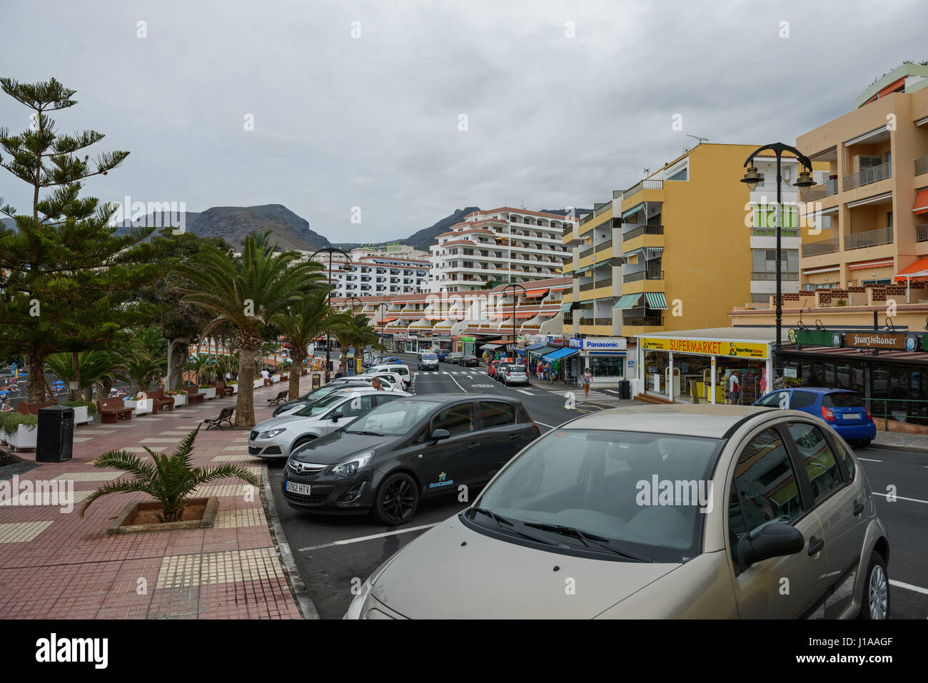 Vista de la Av. Maritima con apartamentos Seguro de Sol y el hotel Playa de  la arena en Puerto de Santiago en días nublados, de la isla de Tenerife,  Islas Canarias Fotografía