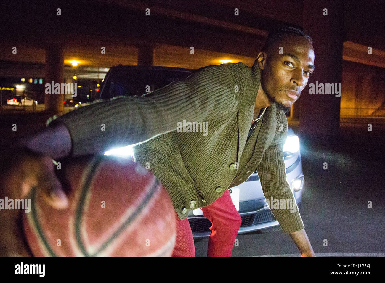Faros brillando en hombre Negro jugando baloncesto Foto de stock