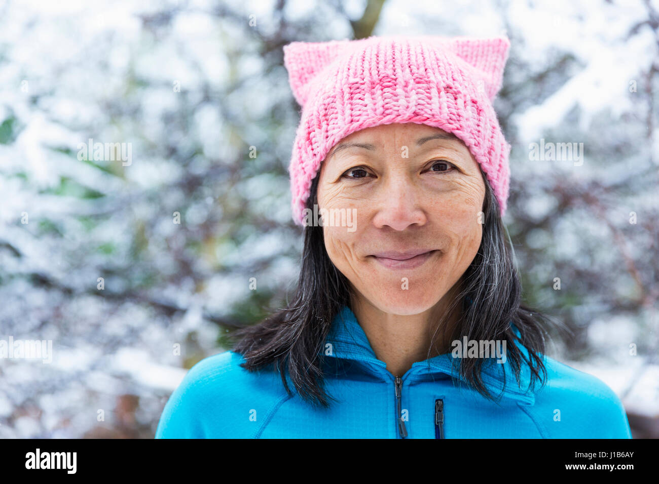 Japonés sonriente mujer vistiendo sombrero de color rosa con orejas Foto de stock