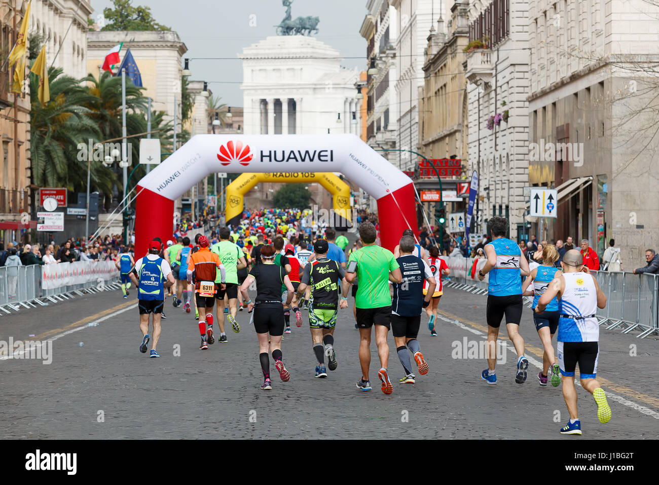 Roma, Italia - Abril 2, 2017: Los atletas de la 23ª Maratón de Roma al paso en la Via Nazionale, a pocos kilómetros de la meta. En el fondo la mo Foto de stock