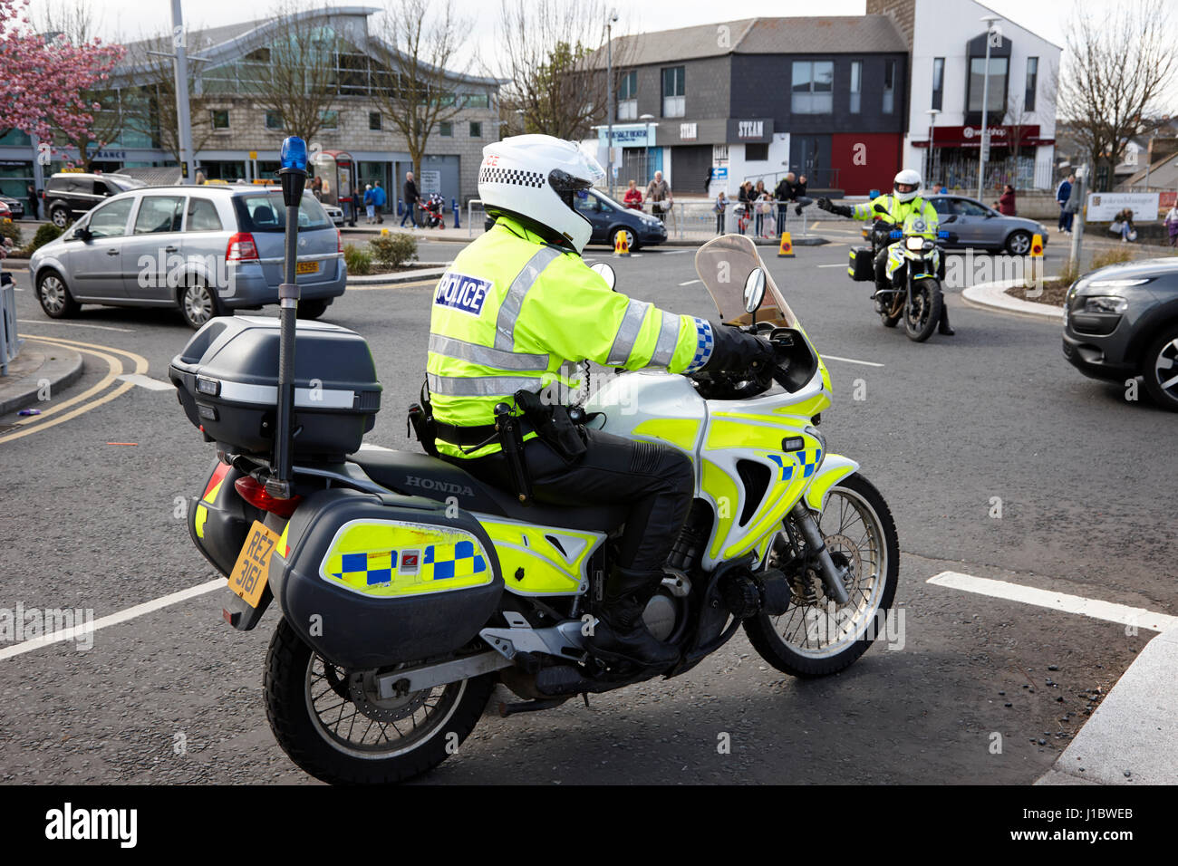Psni oficial de policía la policía de tráfico de motos Honda dirigiendo el tráfico en la rotonda de Irlanda del Norte Foto de stock