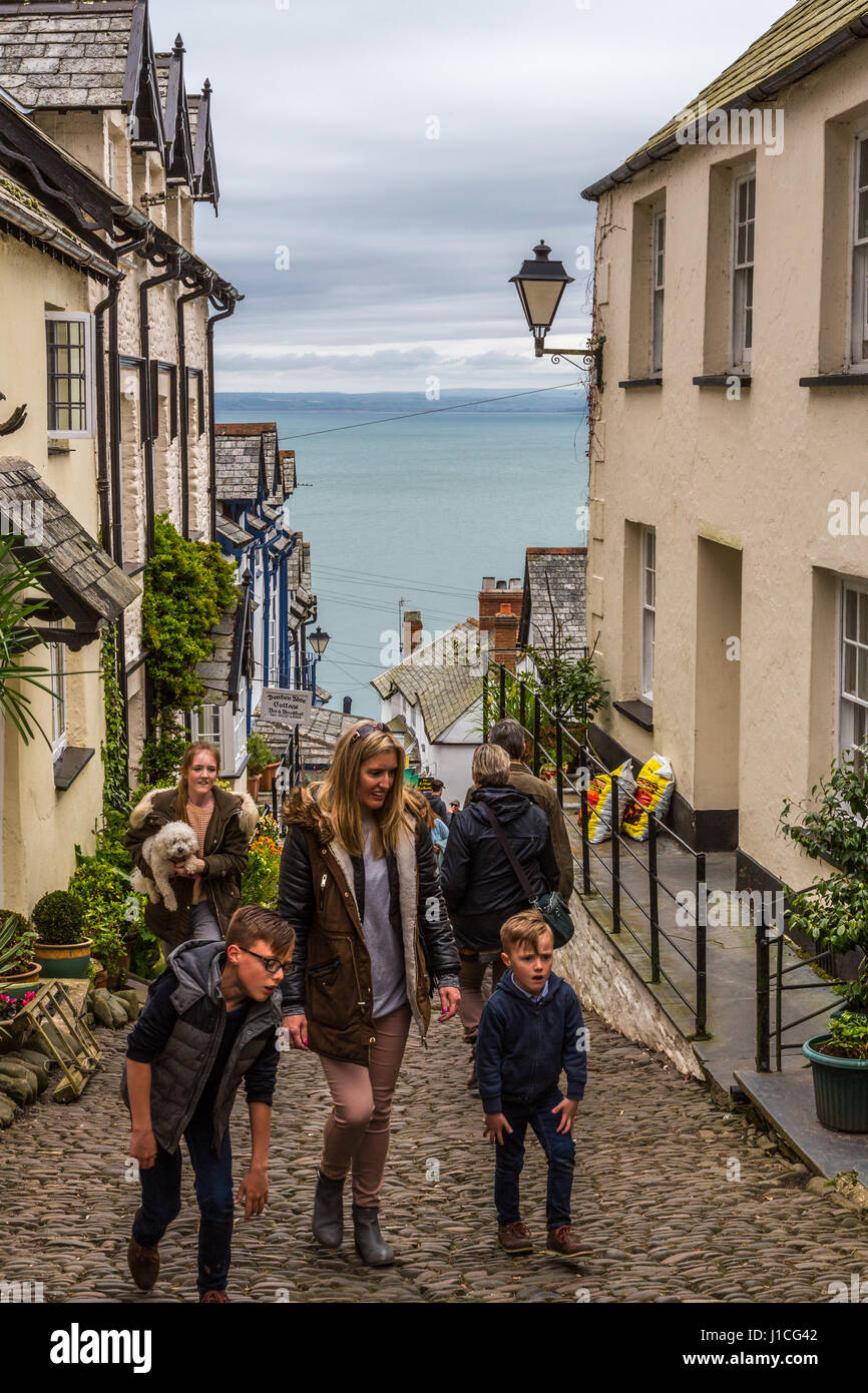 Clovelly, Devon, Inglaterra, Reino Unido. Los visitantes y turistas disfrutan de la empinada calle empedradas y pintorescas casas de esta aldea apartada en Devon Foto de stock