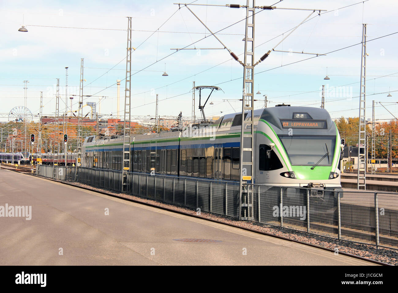 HELSINKI, Finlandia - Octubre 6, 2016: moderno tren de cercanías sale de la estación de trenes de Helsinki en un hermoso día de otoño. Foto de stock